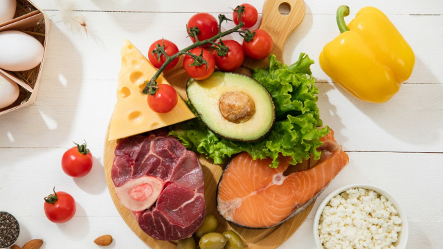 Ketogenic low carbs diet - food selection on white wooden background. Balanced healthy organic ingredients of high content of fats. Nutrition for the heart and blood vessels. Meat, fish and vegetables.