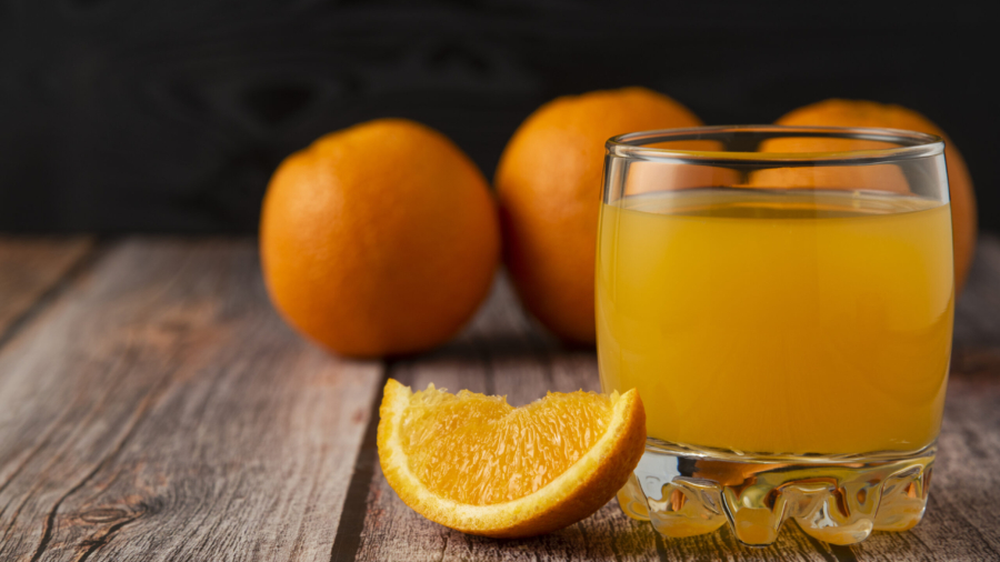 Orange fruit with a glass of juice on the wooden table. High quality photo