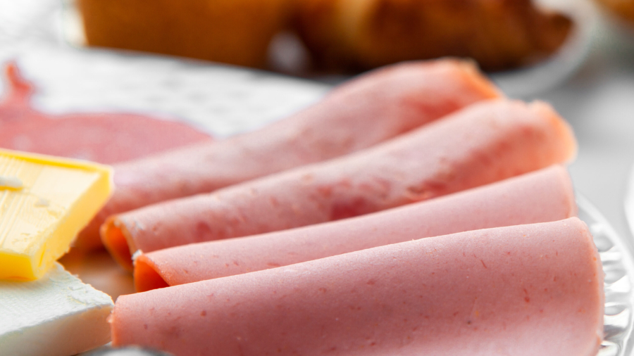 High angle view sliced sausage in plate, with pastry on table