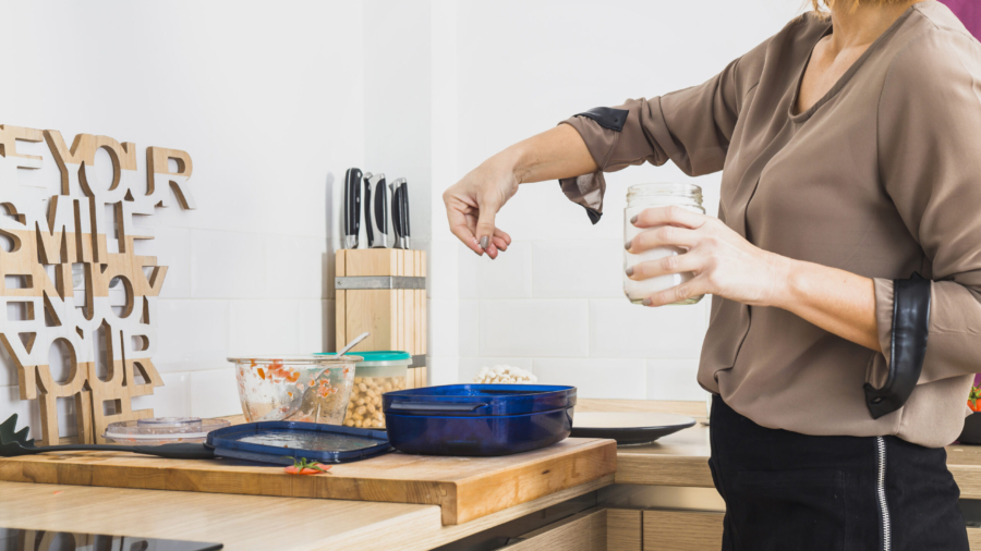 female-standing-kitchen-salting-food